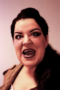 a woman with black hair and a smile on her face