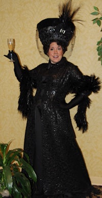 a woman in a black costume holding a glass of wine