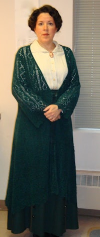 a woman in a green dress standing in an office