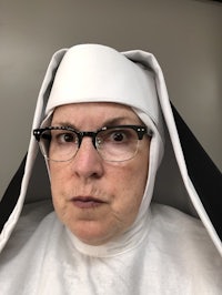 a woman in a nun costume looking at the camera