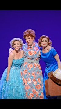 three women in blue dresses are posing for a picture