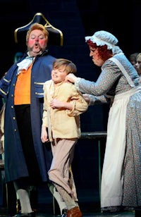a young boy is being helped by a man in a costume