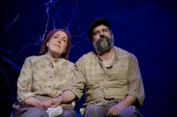 a man and a woman sitting on a stage