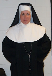 a woman dressed as a nun standing in a room