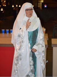 a woman dressed as a nun is standing in front of a bar