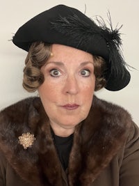 a woman wearing a black hat and fur collar