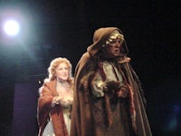 a man and woman dressed in costumes on stage